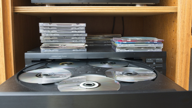 A multi-disc CD changer with a stack of assorted CDs
