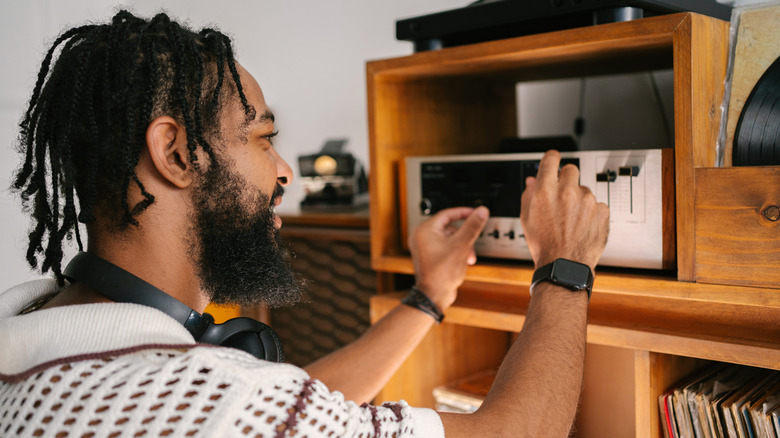 A man adjusting a vintage audio hi-fi system
