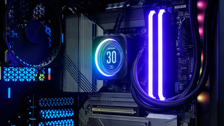 A liquid-cooled gaming PC interior with RGB RAM and a CPU cooler display.