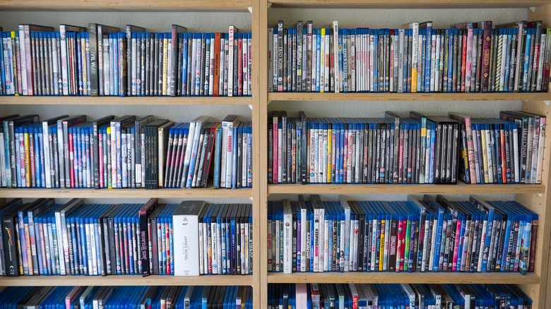 A shelf filled with a lot of different Blu-rays and DVDs