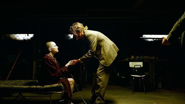 Still of Jesse Plemons and Emma Stone's characters in the movie Bugonia.