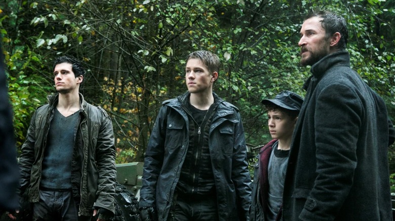 Noah Wyle, Drew Roy, Maxim Knight, and Connor Jessup stand together in Falling Skies