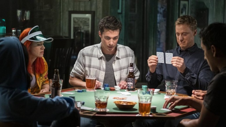 Alice Wetterlund, Levi Fiehler, and Alan Tudyk sit around a poker table in Resident Alien