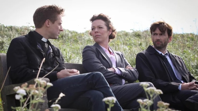 Arthur Darvill, Olivia Colman and David Tennant sat on a bench in Broadchurch