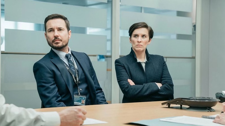 Martin Compston and Vicky McClure sat at a table in Line of Duty