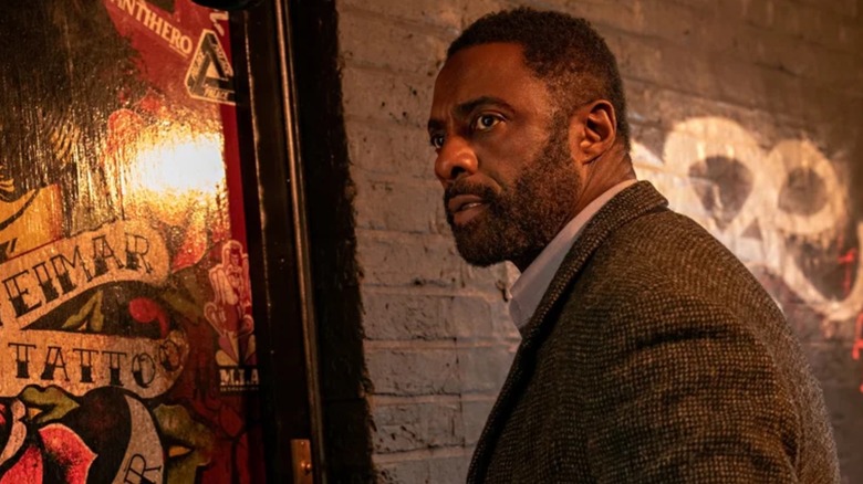 John Luther (Idris Elba) stood against a wall