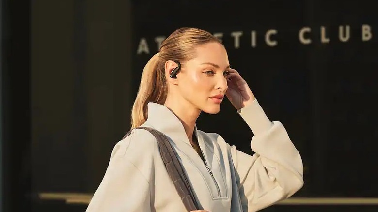 Beats Powerbeats Pro 2 being worn and interacted with one hand