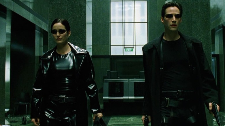 Trinity (Carrie-Ann Moss) and Neo (Keanu Reeves) in the hallway in The Matrix
