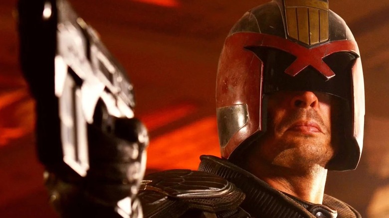 Karl Urban as Dredd holding his Lawgiver in Dredd
