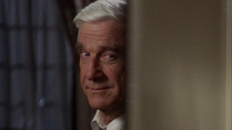 Frank Drebin smirking behind a wall in "The Naked Gun: From the Files of Police Squad"