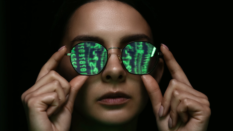 Woman  with code reflecting in her tinted glasses