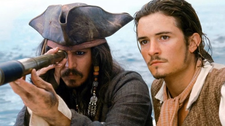 Johnny Depp looking though a periscope stood next to Orlando Bloom in Pirates Of the Caribbean: The Curse of the Black Pearl