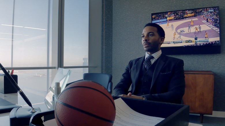Ray Burke sitting at a desk, frowning, in "High Flying Bird."