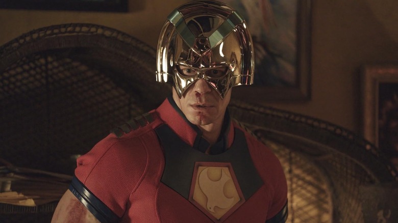 Peacemaker (John Cena) looking down with a bloody nose in Peacemaker