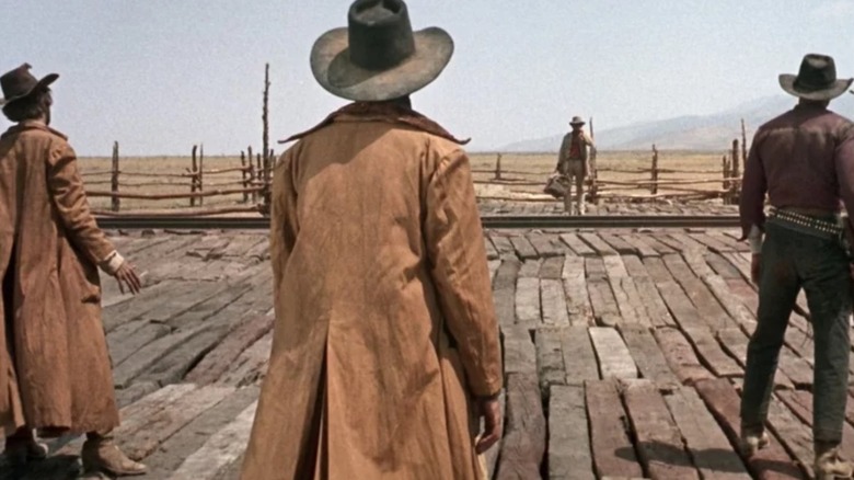 Three cowboys in dusters facing a man on a railway track in "Once Upon A Time In The West."