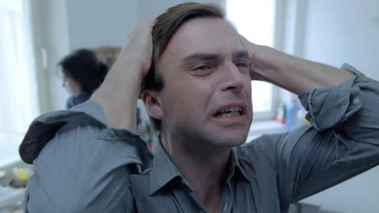Mark with his hands behind his head and frowning in "Possession."