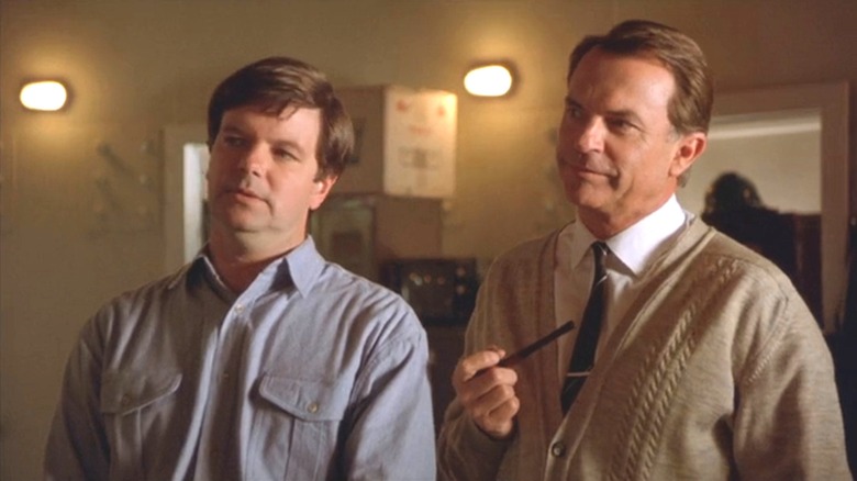 Mitch smiling and Cliff holding a pipe in "The Dish."