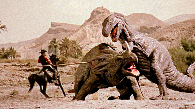 A man on a horse stabbing a dinosaur that's being attacked by another dinosaur in "The Valley of Gwangi."