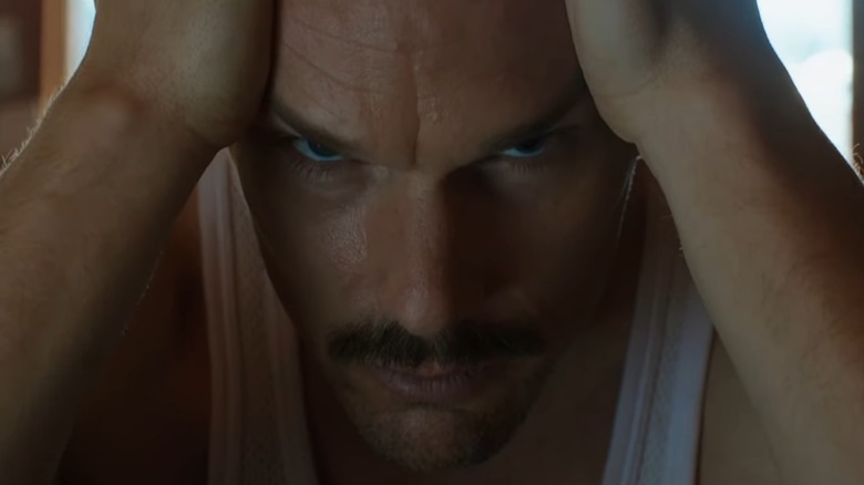 Ethan Hawke facing forward with his hands on his head in Predestination