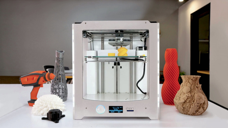 3D printer on table surrounded with print projects
