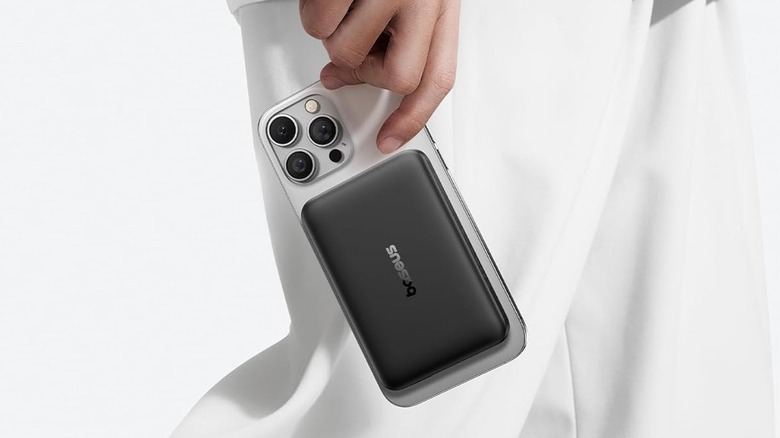 A person holding an iPhone with Baseus EnerFill FM12 power bank attached