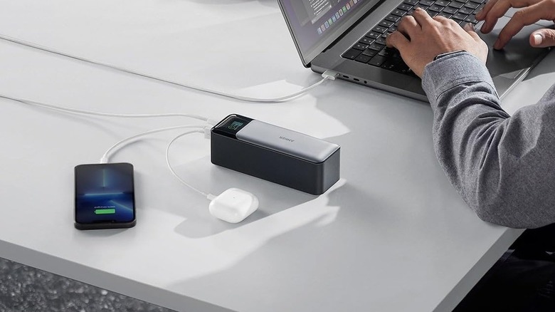 Anker 737 Power Bank on a desk connected to an iPhone, AirPods, and a MacBook
