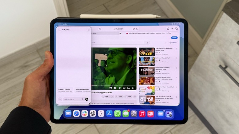A hand holding an iPad with Slide Over on