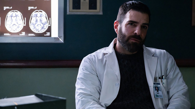 Oliver sitting in his office looking pensive in Brilliant Minds.