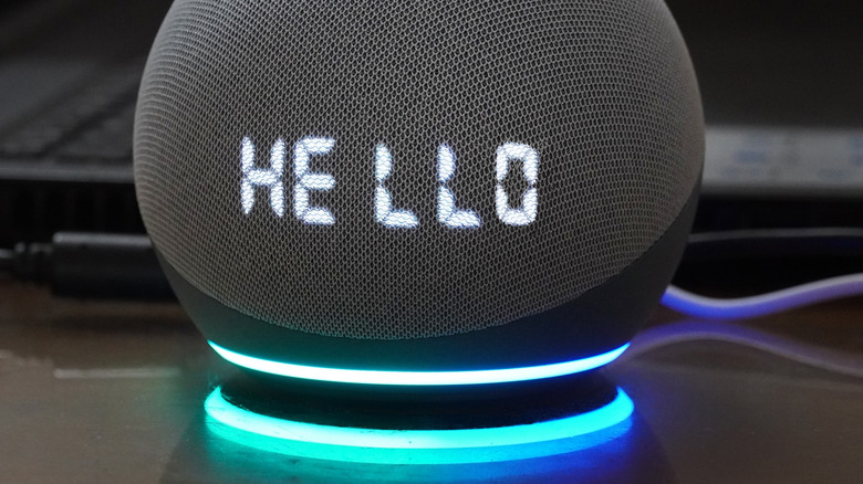 An Amazon Echo Dot with its lights glowing