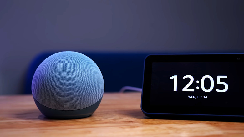 An Echo Dot next to an alarm clock on a table