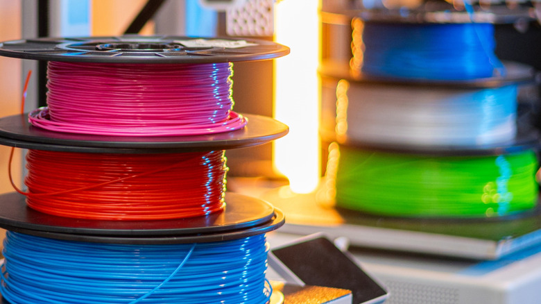 Stacks of 3D printer filament sat on top of a 3D printer bed.