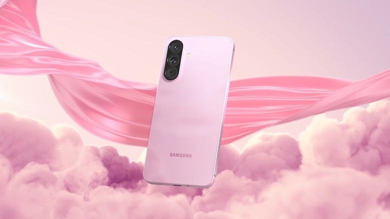 Pink Samsung Galaxy A56 showing its triple rear camera setup against a pink cloud background.