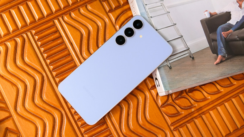 Samsung Galaxy S25 FE kept face down on a table showing its triple rear camera setup.