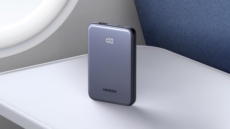 The Ugreen Nexode Power Bank 10K on an airline seat tray table