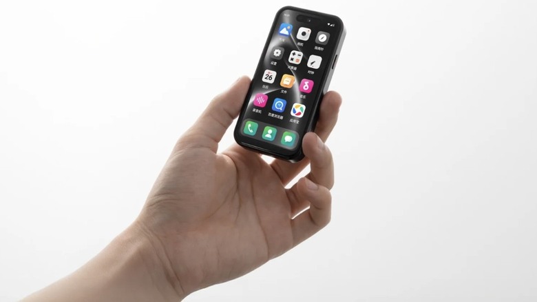 A hand holding the compact Bluefox NX1 smartphone, showing its touchscreen with app icons.