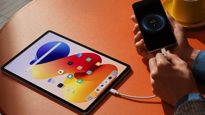 The Redmi Pad 2 Pro tablet used to recharge a smartphone.