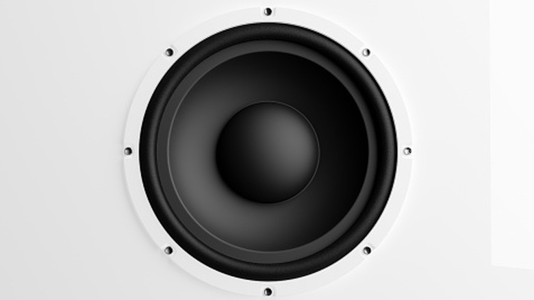 A closeup of a black speaker surrounded by a white enclousre
