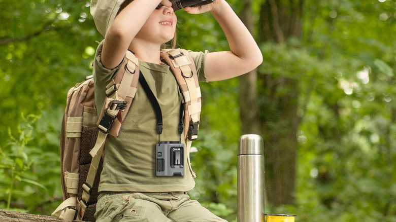 Wearing the Comlife portable waist fan while looking through binoculars