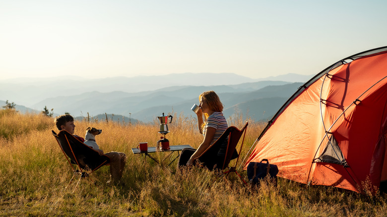 Sitting in a field with a tent overlooking rolling hills