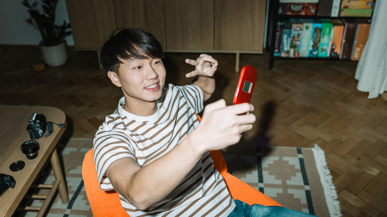 A person using flip phone to take a selfie