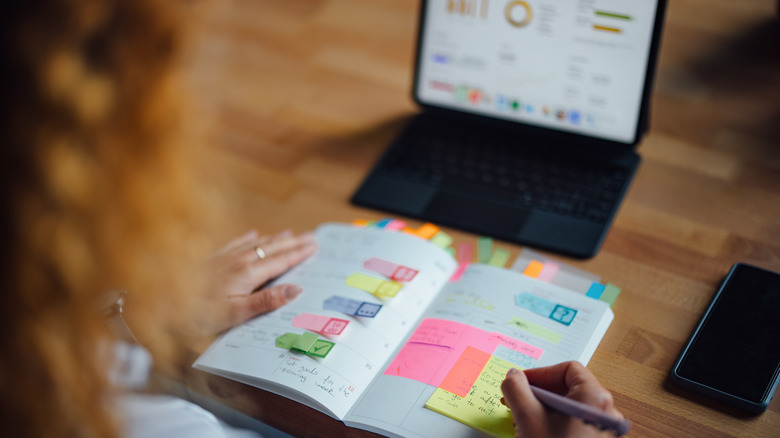 a person working on their planner with a table open in the background