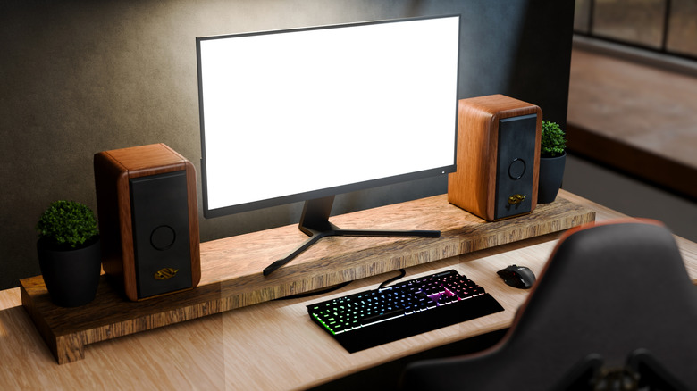 A computer monitor on a desk with speakers on either side