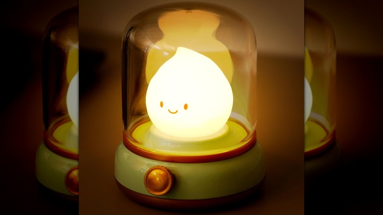 A Wanidea Chibi Flame Lamp lit up on a table.