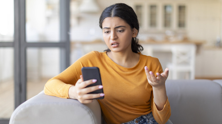 Woman looking frustrated with her smartphone