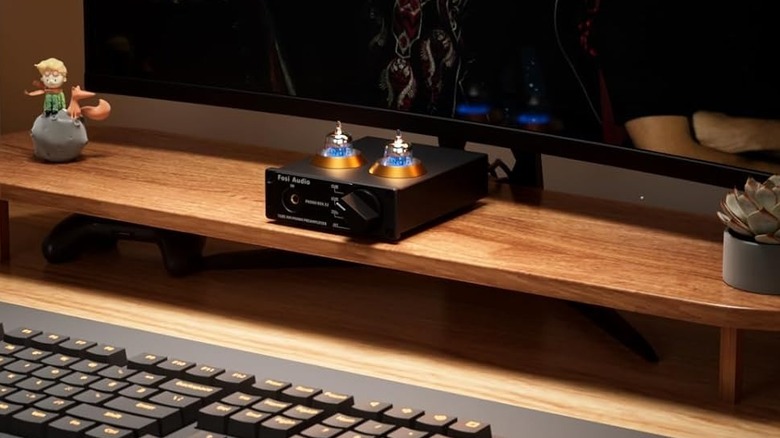 The Fossi Audio Box X2 DAC sitting on a desktop monitor riser on a desk