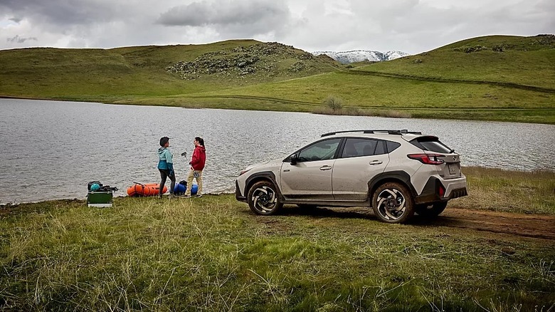 Subaru Crosstrek in the wilderness by the water with drivers nearby.