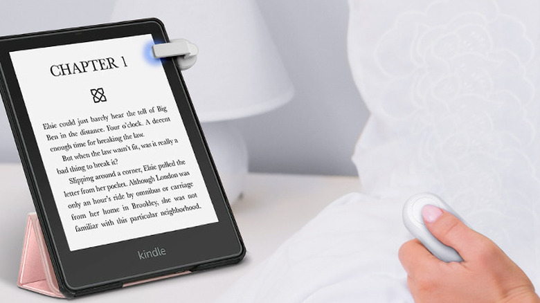 Hand holding remote to DATAFY Remote Control Page Turner connected to Kindle