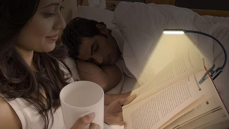 Person using Gritin 9 LED Rechargeable Book Light clipped to book while reading in bed