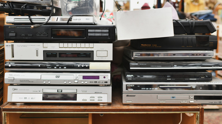 Assorted vintage physical media players stacked