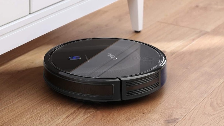 The Eufy 11S Max cleaning near the legs of a white table.